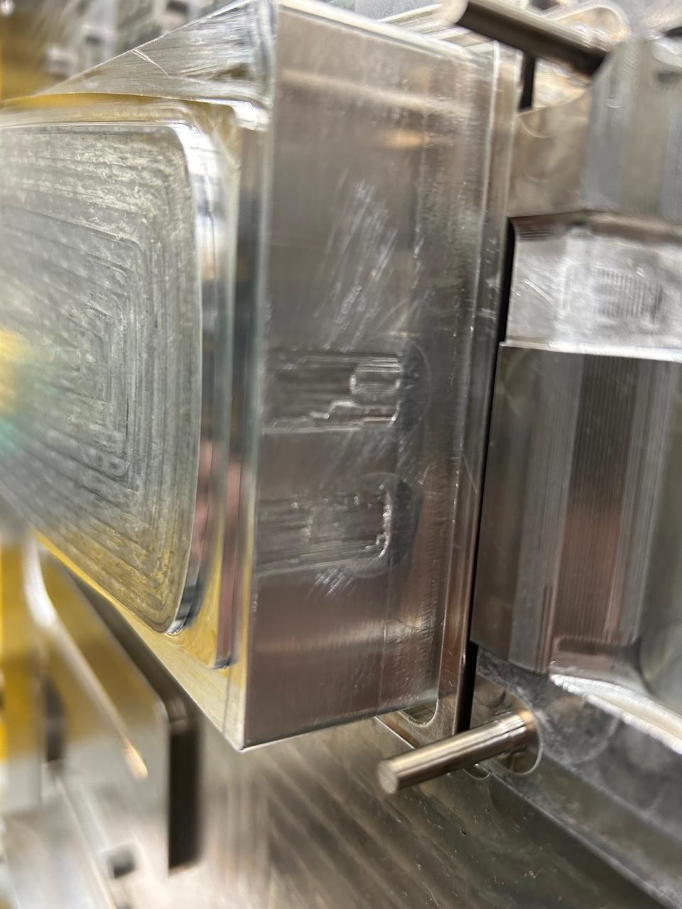Nahaufnahme einer CNC-gefrästen Kavität mit sichtbaren Fräsbahnen und Schiebermechanik